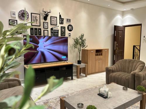 un salon avec une grande télévision à écran plat dans l'établissement شقة فاخرة غرفتين وصالة النرجس ١٥, à Riyad