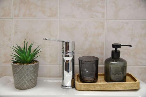 a soap dispenser and a bottle on a bathroom sink at Η μονοκατοικία της Χαράς. in Kalamáki