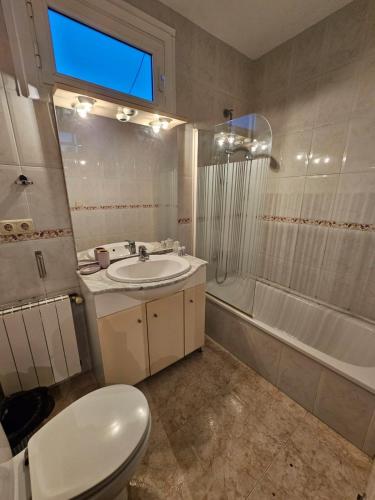 a bathroom with a toilet and a sink and a tub at Hotel Wellamar in Sant Feliu de Guíxols