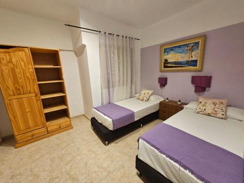 a hotel room with two beds and a shelf at Hotel Wellamar in Sant Feliu de Guíxols
