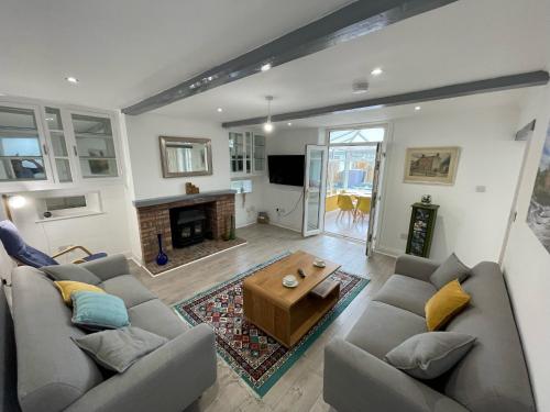 a living room with two couches and a fireplace at Spacious Cottage with Private Hot Tub in Baildon