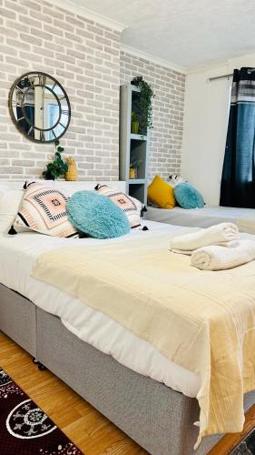 two beds in a bedroom with a brick wall at Whites Inn in London
