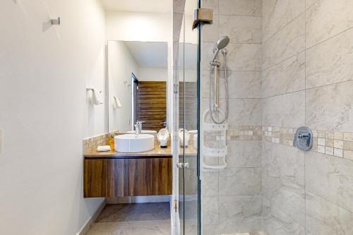 a bathroom with a sink and a glass shower at La Selva 303 Sirenis in Akumal