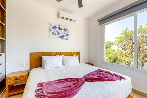 a bedroom with a bed and a window at La Selva 303 Sirenis in Akumal