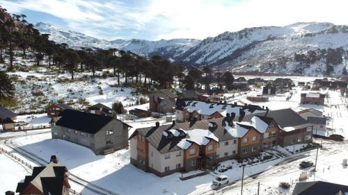a town covered in snow with mountains in the background at Villa Maihue departamentos de montaña - Caviahue in Caviahue