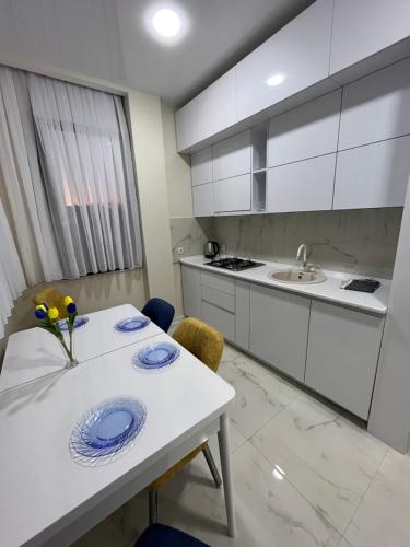 uma cozinha com uma mesa branca com placas azuis em MT House em Batumi
