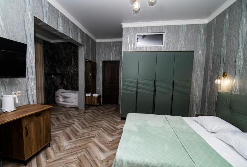 a bedroom with a large bed and a bathroom at Hotel Black Sea in Sukhum