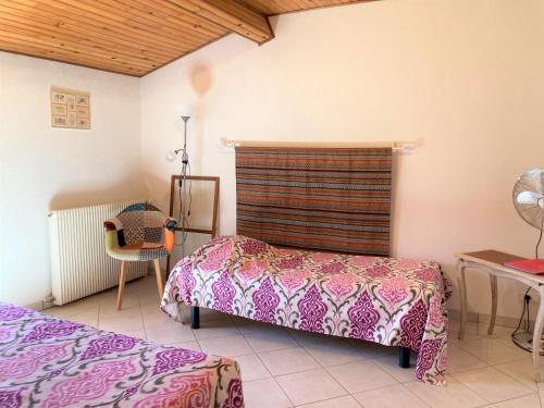 1 dormitorio con 2 camas, mesa y silla en La Halte de Segondignac, en Saint-Germain-dʼEsteuil