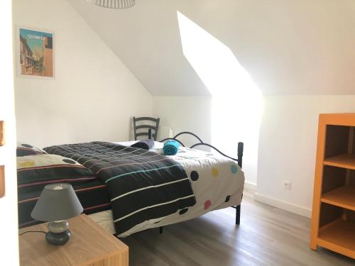 een slaapkamer met een bed met een zwart-wit dekbed bij Maison 8 personnes à 4 km de Bénodet in Gouesnach