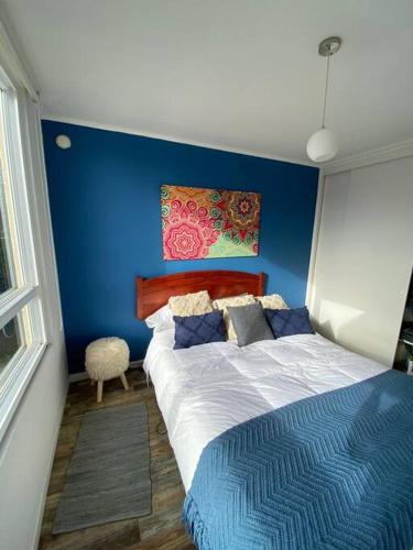 Ce lit se trouve dans un dortoir doté d'un mur bleu. dans l'établissement Lomas Apart Papudo, à Papudo