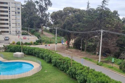 - une piscine dans un parc à côté d'une route dans l'établissement Lomas Apart Papudo, à Papudo