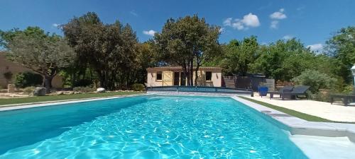 une piscine avec de l'eau bleue dans une cour dans l'établissement La Pitchounette Mas Val-Chênaie Gordes, à Gordes