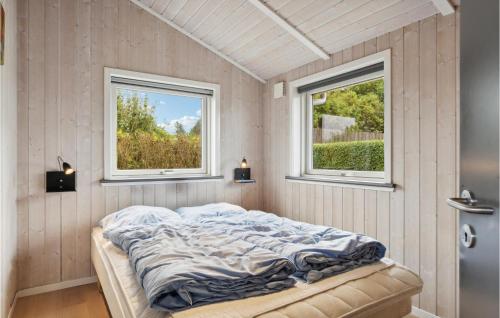 a bed in a room with two windows at Stunning Home In Esbjerg V With Kitchen in Esbjerg