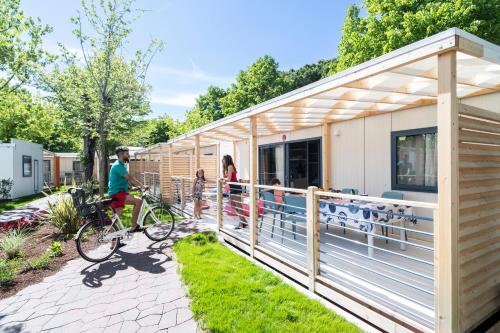 a family standing outside of a tiny house at Camping Village Garden Paradiso in Cavallino-Treporti
