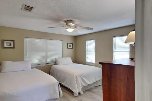 a bedroom with two beds and a ceiling fan at The Yellow House in Gulf Breeze