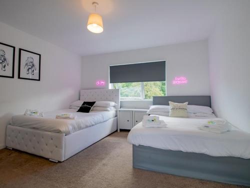 1 dormitorio con 2 camas y ventana en Pass the Keys Stunning Newcastle Home en Elswick