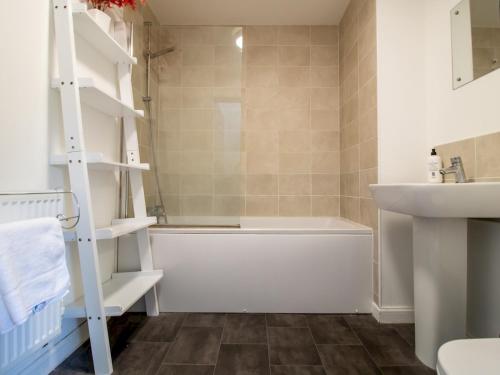 a bathroom with a white bath tub and a sink at Pass the Keys Stunning Newcastle Home in Elswick