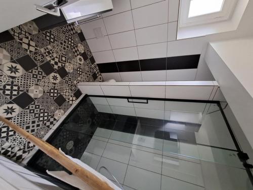 un escalier en verre avec du carrelage noir et blanc dans l'établissement Agréable T2 Classé 3 étoiles, refait à neuf, dans quartier calme, à Rodez
