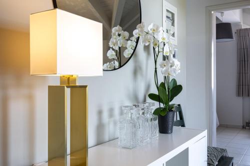 eine Lampe auf einem Tisch mit Brille und Blumen in der Unterkunft Domus City Apartment in Argostoli