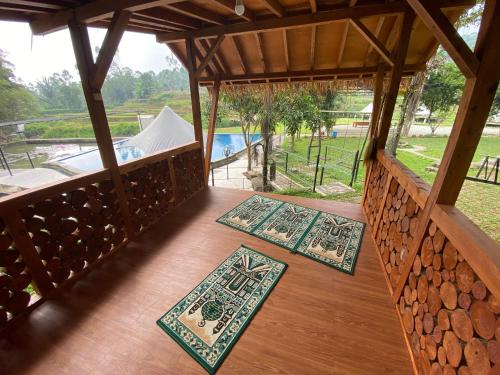 two rugs on the floor of a porch with a pool at Shine River in Ciwidey