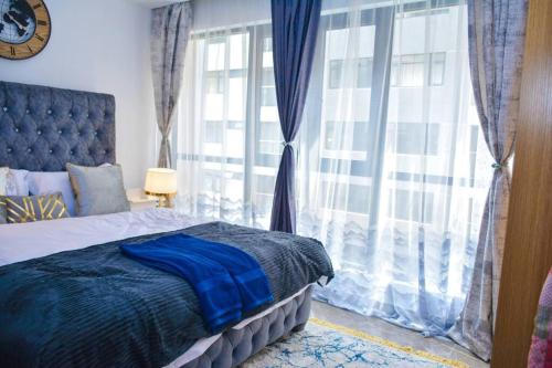 a bedroom with a bed and a large window at Lovely instantworthy Premier One Bedroom Apartment in Nairobi