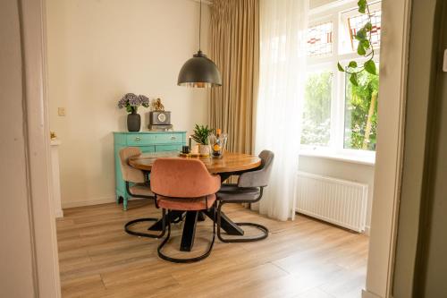 a dining room with a table and chairs and a window at Kapiteinshuisje in Harderwijk