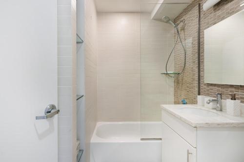 a white bathroom with a sink and a shower at 809-3A 1BR Columbus Circle Elevator W D in New York