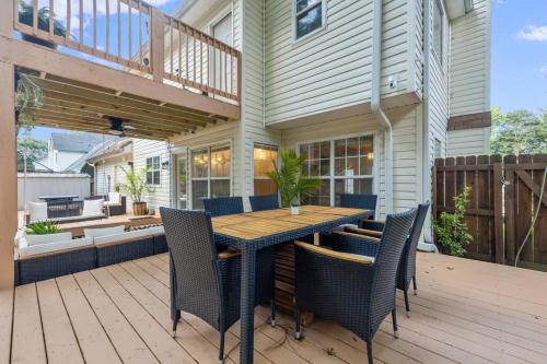 un patio con una mesa de madera y sillas en una terraza en Convenient City Retreat, 10mins from ATL Airport, en Riverdale