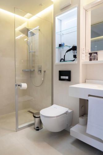a bathroom with a toilet and a glass shower at The Dome Hotel in Satu Mare