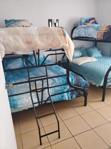 a room with two bunk beds and a couch at Villa Roberto Vista Hermosa in Sardinal