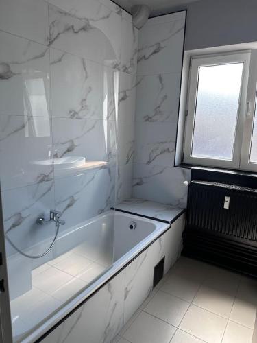 a white bathroom with a tub and a window at Maurice en ville n14 in Namur