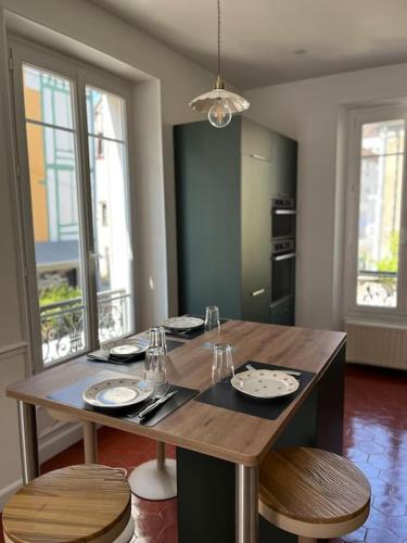 une table à manger avec deux chaises et une table avec des assiettes et des verres dans l'établissement La Belle du Val, à Provins
