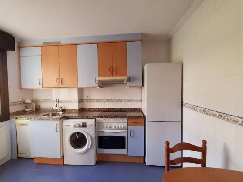 a kitchen with a refrigerator and a washing machine at Apartamento El Horrín ( Colunga ) in Colunga