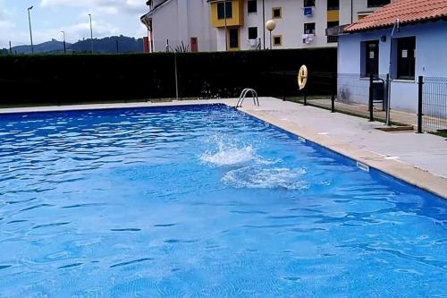 a swimming pool with a dolphin in the water at Apartamento El Horrín ( Colunga ) in Colunga