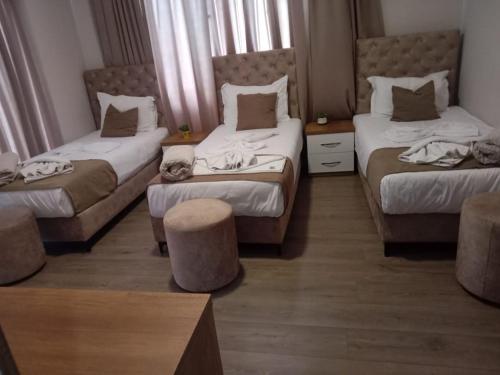 a hotel room with two beds and a table at Hotel Princ in Shkodër