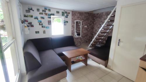 uma sala de estar com um sofá e uma escada em T-Lak Vendégház Tiszalök em Tiszalök