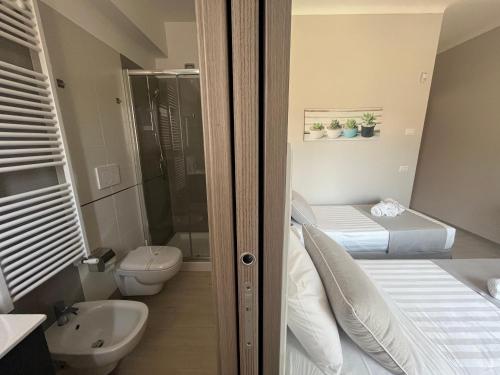 baño con 2 camas, aseo y lavamanos en B&B L’ALTRAMURGIA, en Cassano delle Murge
