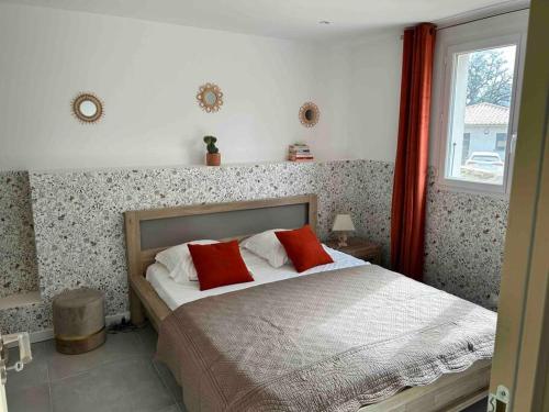 a bedroom with a bed with red pillows and a window at Casa Bella - 4 couchages - 6 minutes Plages in Porto-Vecchio
