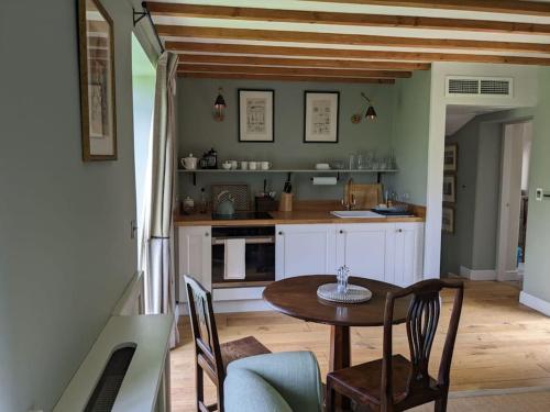 a kitchen with a wooden table and a table and chairs at Cottage in Matlock, Derbyshire. Lower Holly Barn in Matlock Bank