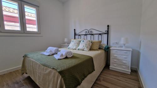 Casa vacacional en Chiclana de la Frontera في شيكلانا دي لا فرونتيرا: غرفة نوم عليها سرير وفوط