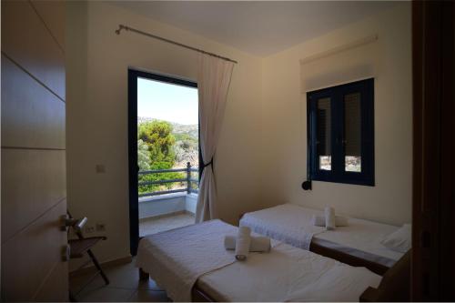 Zimmer mit 2 Betten und einem Balkon mit Fenster in der Unterkunft Lazy Days in Klíma