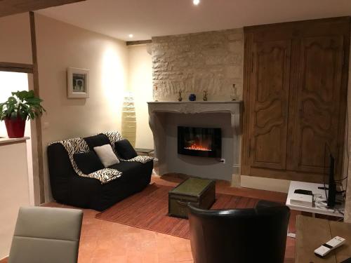 un salon avec un canapé et une cheminée dans l'établissement Au poids du Roy, à Noyers-sur-Serein