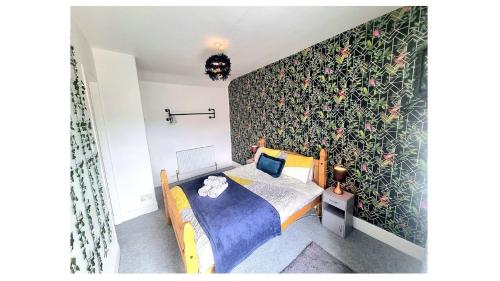 巴克斯頓的住宿－Torr Mews，一间卧室配有一张带花卉图案墙壁的床