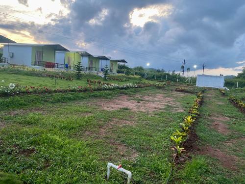 a field with houses and a field with flowers at Sapthapadi Villas in Lammasingi