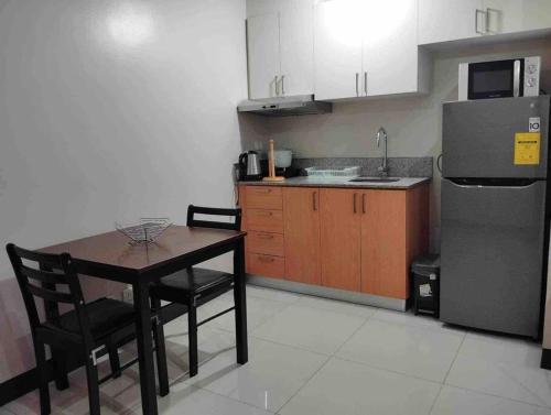 a small kitchen with a table and a refrigerator at Spacious 1 bedroom unit in Araneta Center Cubao in Manila
