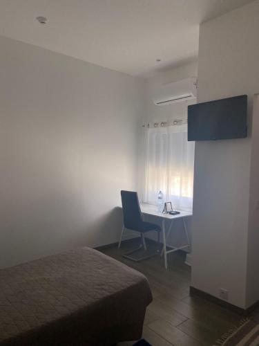 a room with a bed and a desk and a table at RM newhost 2015 / CasaDoChico in Portalegre