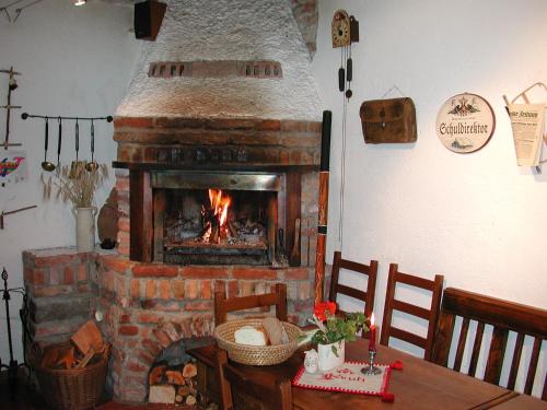 a brick fireplace in a dining room with a table and a table at Apartments Wrolich in Latschach ober dem Faakersee
