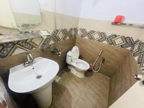 een badkamer met een wastafel en een toilet bij Rehaish Inn in Karachi