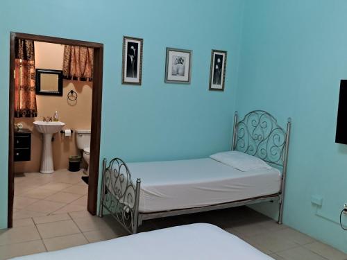 a small bed in a room with a blue light at Banyan Rose in Orange Walk