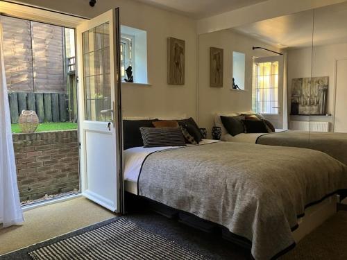 a bedroom with two beds and a window at The Studio in the Annex in Potters Bar